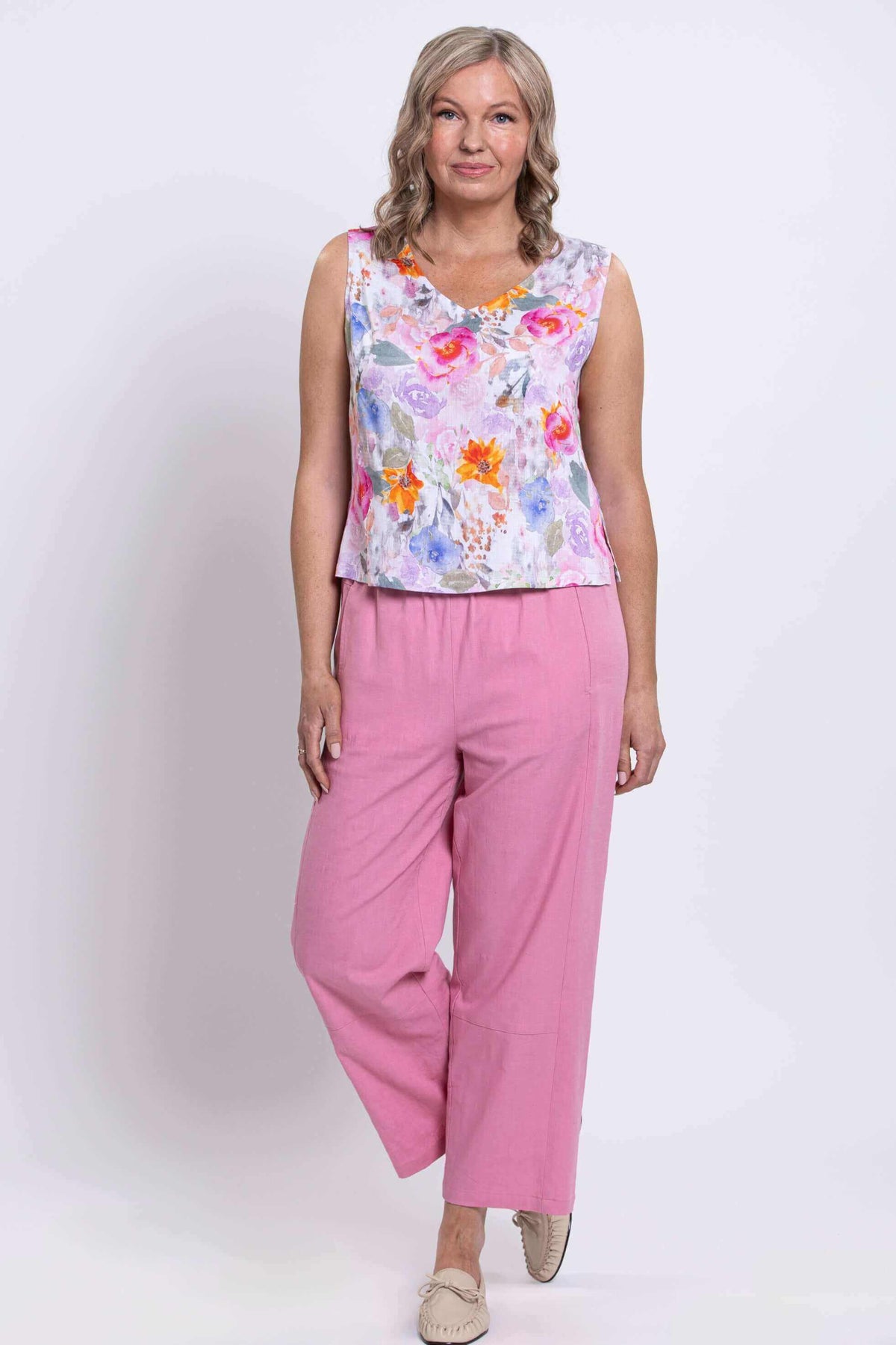 Woman in floral cropped tank with wide straps and pink linen pants
