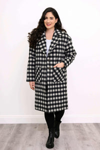 Woman facing forward in a black and white checkered long coat with button closure