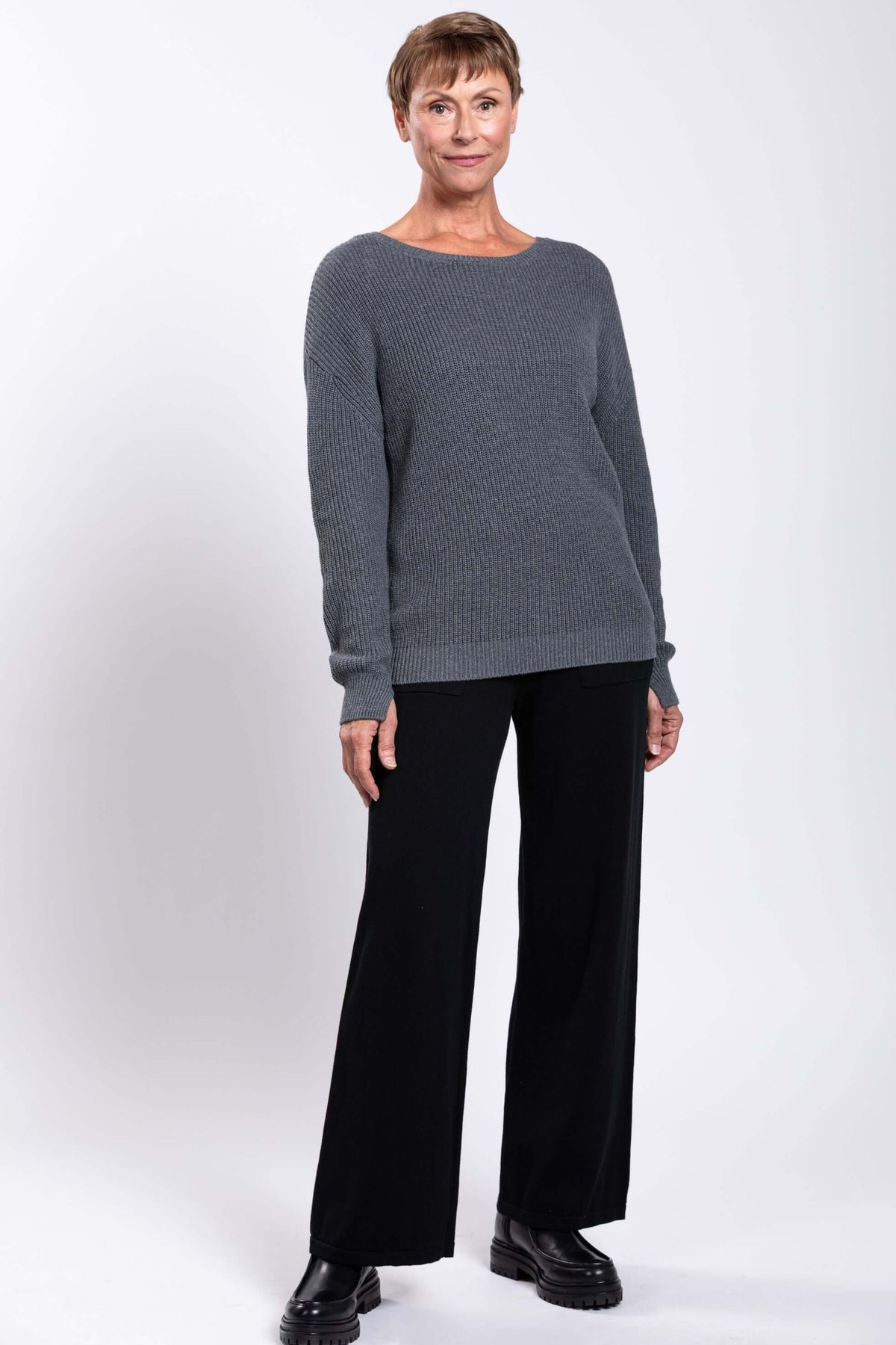 Woman in gray shaker stitch sweater with subtle ribbing and classic fit