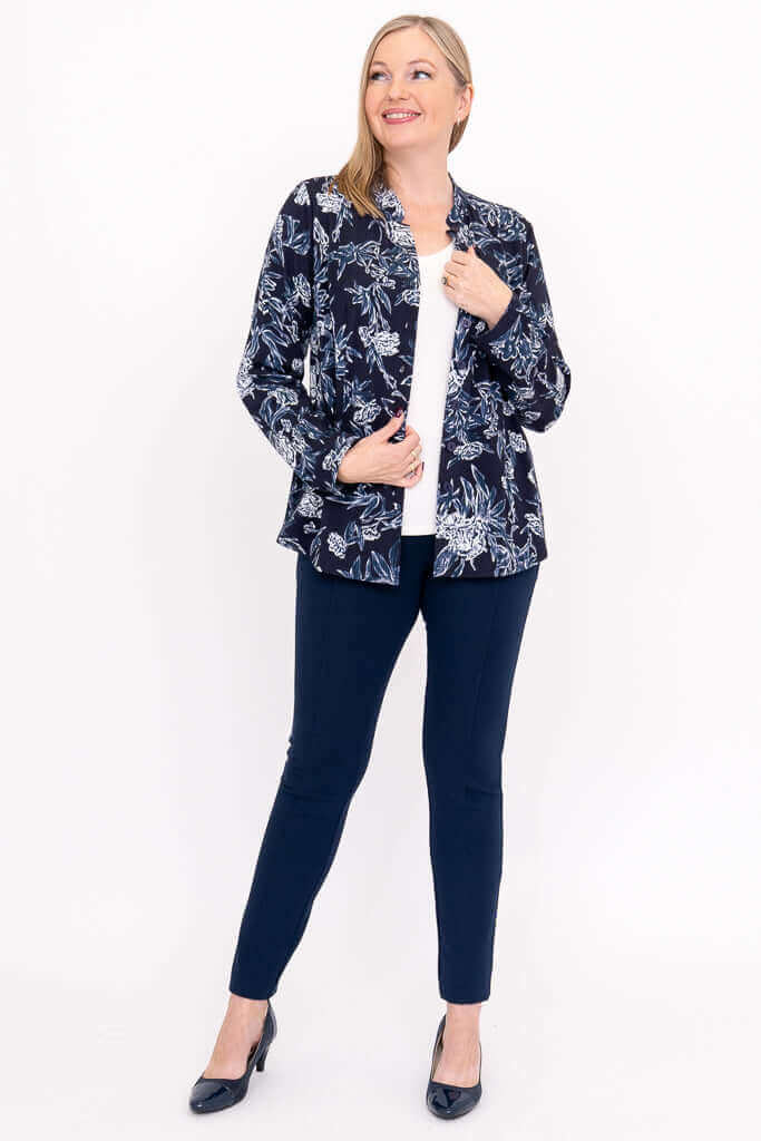 Woman smiling in indigo floral blouse, styled with navy pants, front view