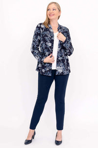 Woman smiling in indigo floral blouse, styled with navy pants, front view