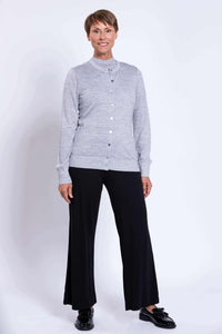 Woman wearing a light grey merino wool button-up cardigan with black pants