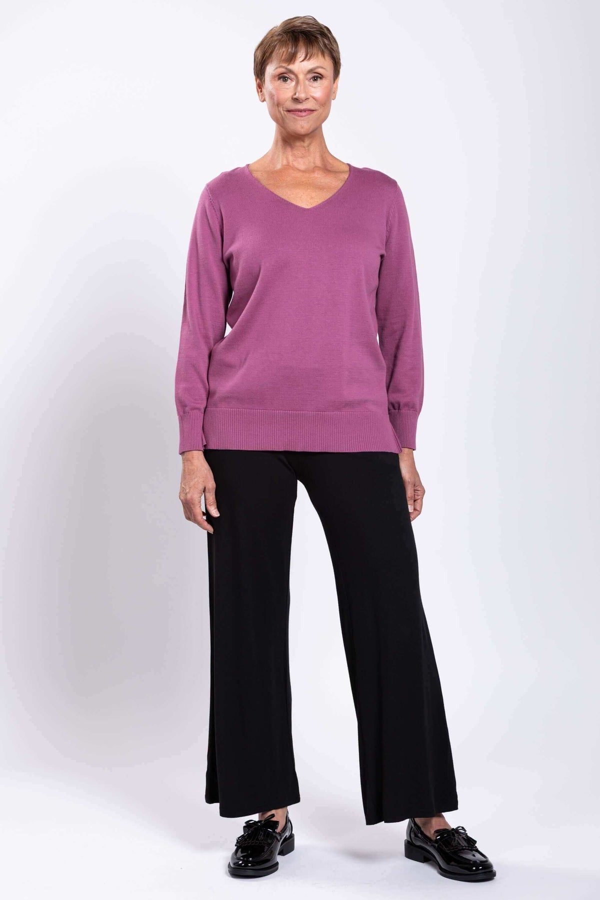 Woman in mauve V-neck cotton sweater shown from the back