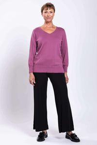 Woman in mauve V-neck cotton sweater shown from the back