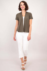 Woman walking in olive green open jacket with short sleeves and white pants