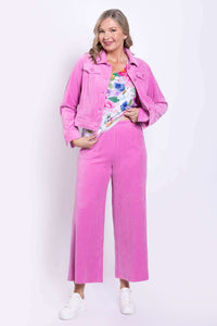 Woman wearing pink corduroy wide-leg pants and matching jacket with floral top