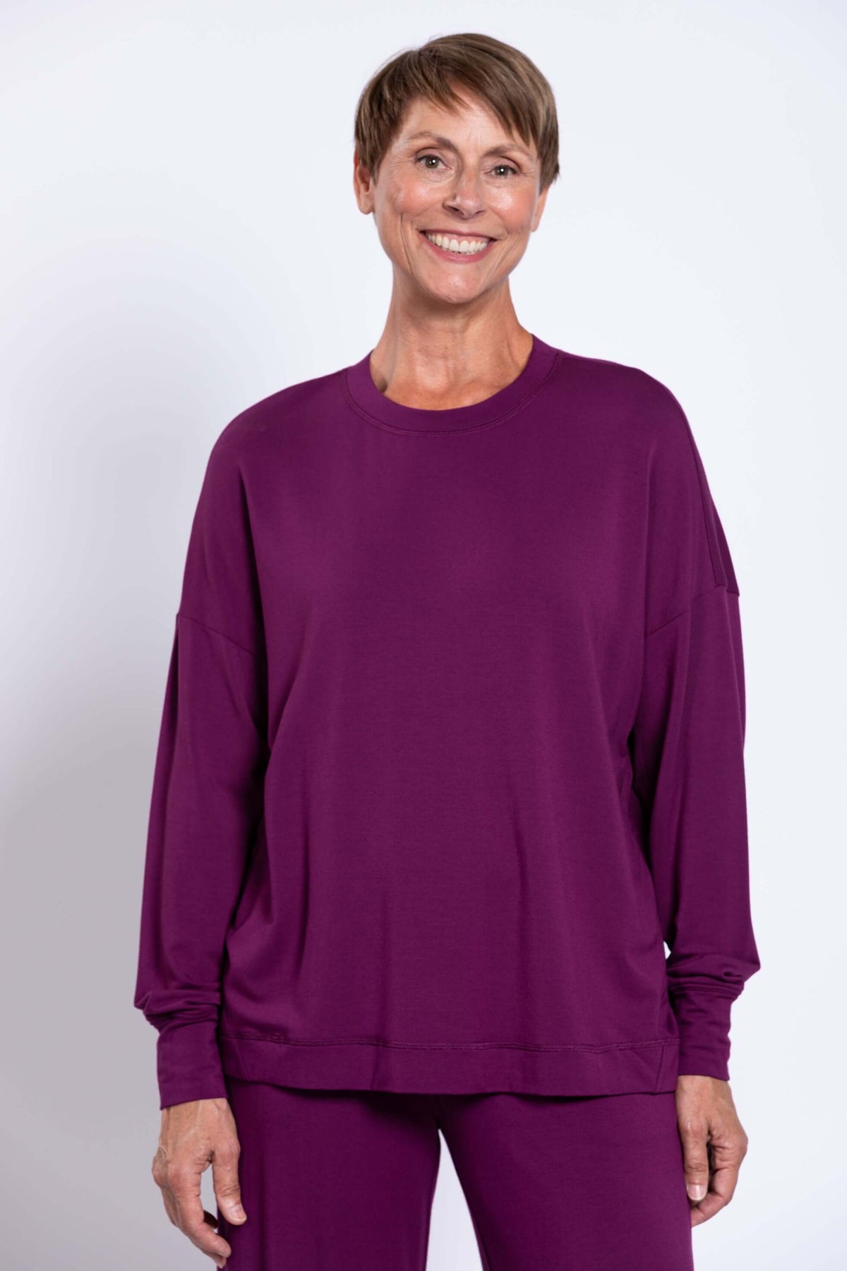Woman wearing a relaxed plum long sleeve crew neck bamboo top with matching pants