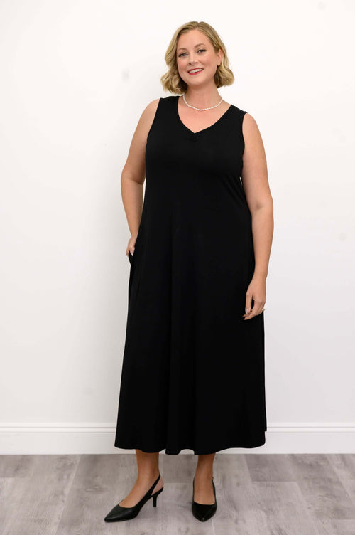 Woman wearing a sleeveless black maxi dress with a ruched V-neck, facing forward
