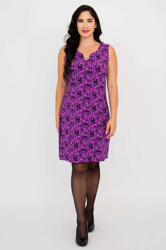 Woman wearing a sleeveless purple patterned shift dress with black heels