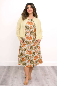 Woman in yellow cardigan over floral sleeveless midi dress with pockets
