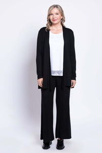 Woman layering white lace tank top with black open cardigan, front view