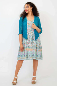 Woman looking sideways in Kayana dress with textured teal cardigan
