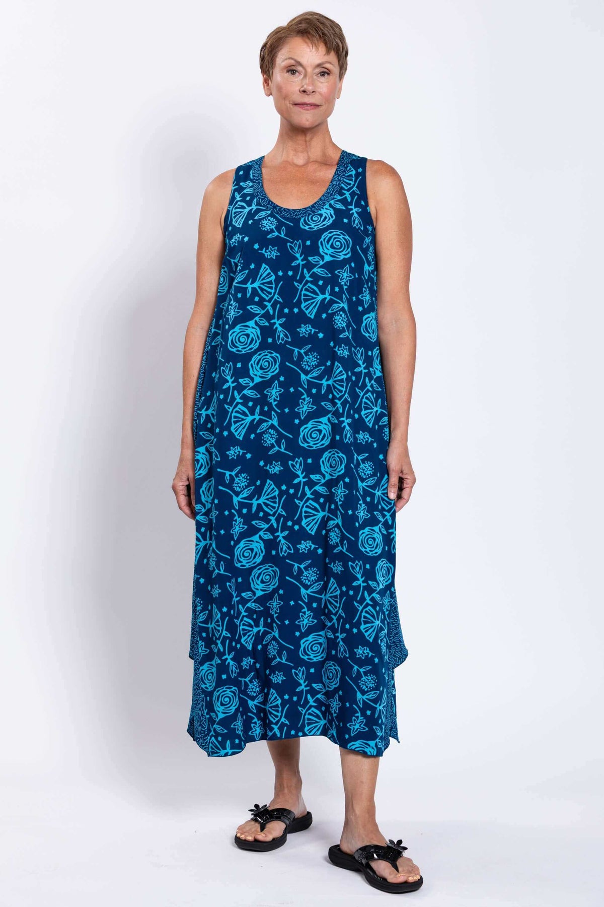 Smiling woman modeling blue floral Ari tank dress with wide shoulder straps