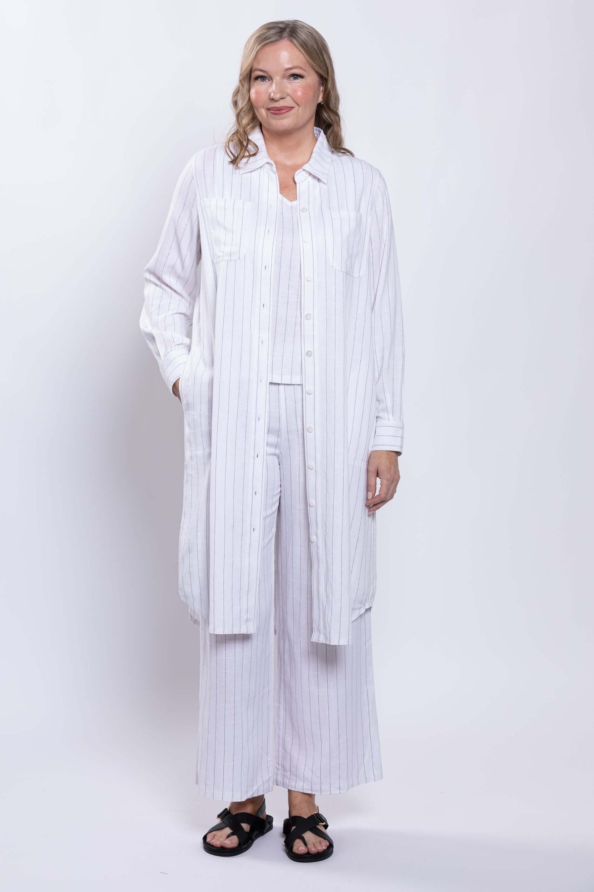 Woman modeling a long striped duster open over matching pants and top
