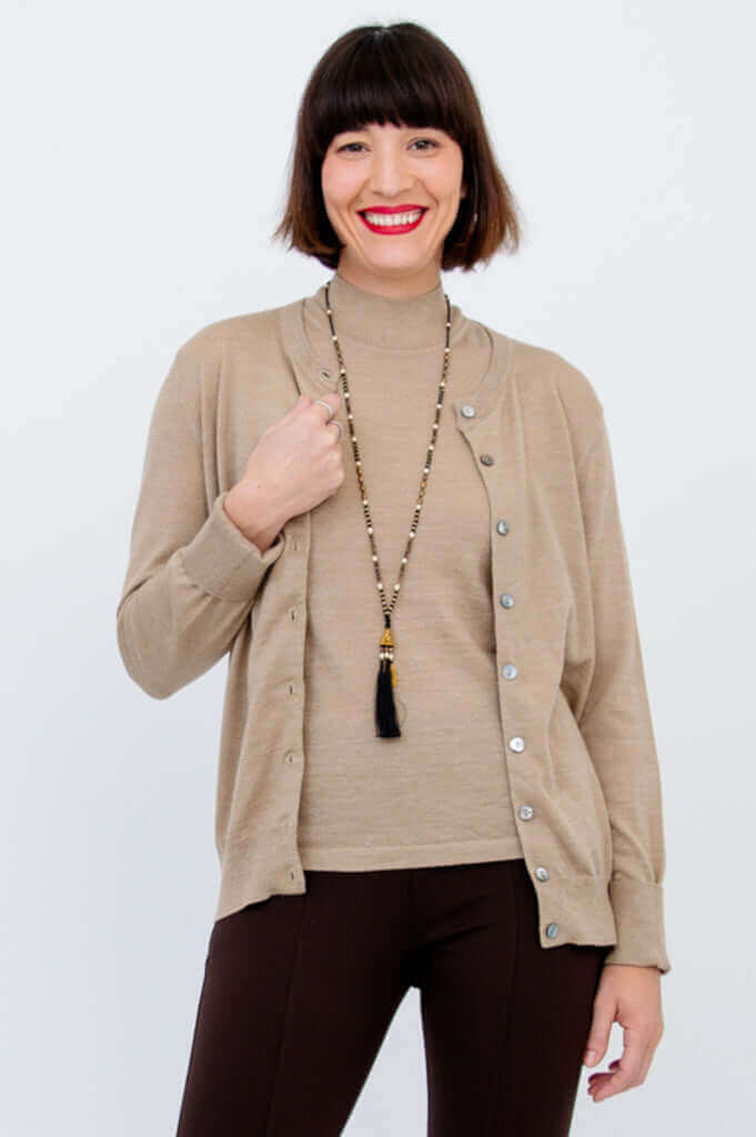 Woman modeling a beige merino wool cardigan open over a matching top