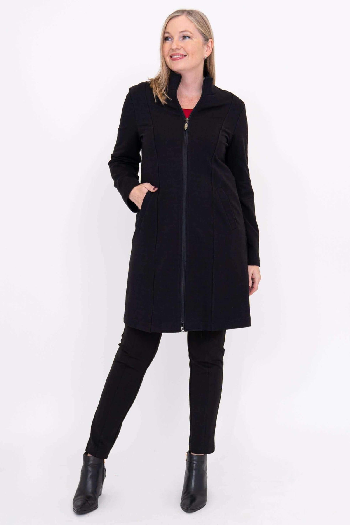 Woman modeling black Tracy Coat over black pants and red top