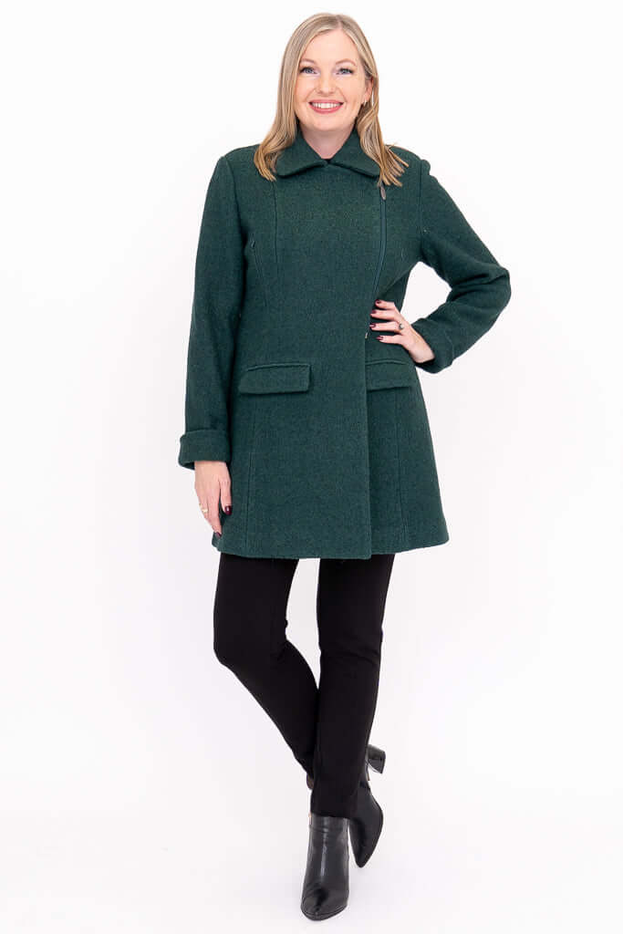 Woman modeling a dark green wool coat in a full body pose