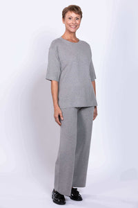 Woman wearing full grey Bailey track pant and matching top, smiling