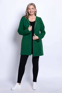 Woman smiling in green hooded jacket, unzipped over black outfit, front view
