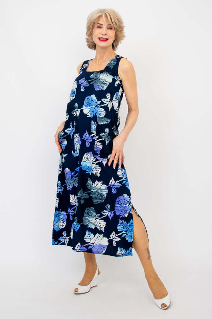 Woman modeling a sleeveless navy blue floral dress with square neckline and calf-length hem