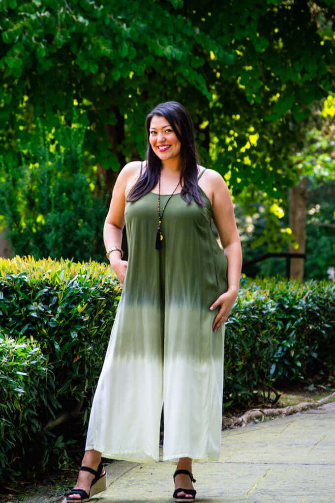 Woman modeling ombre jumpsuit with pockets outside in a garden setting
