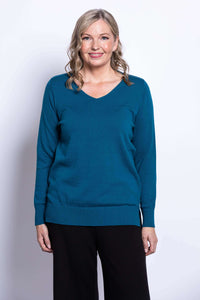 Woman wearing teal v-neck cotton sweater viewed from the front, smiling
