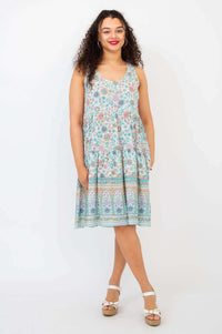 Woman modeling tiered floral Kayana dress in a relaxed pose