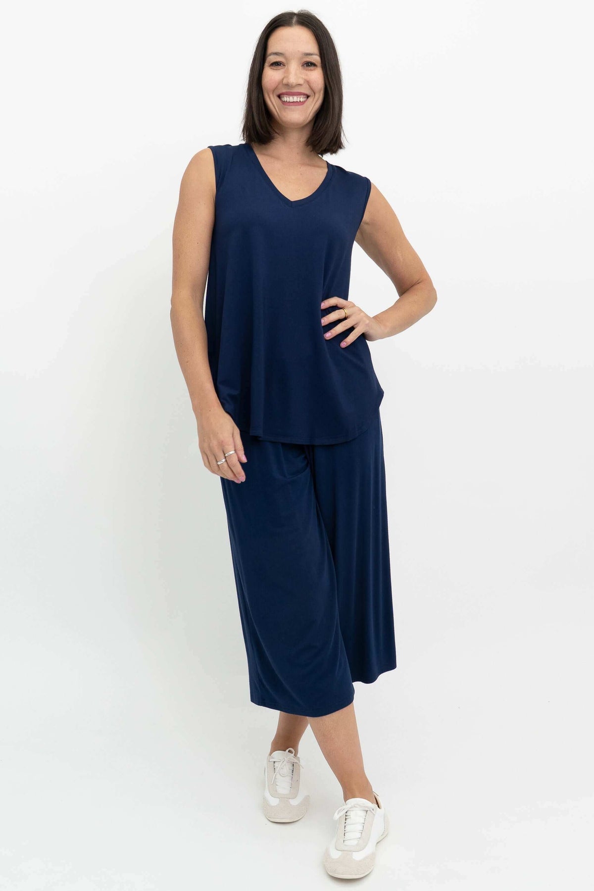 Woman posing in a navy sleeveless bamboo top and matching pants, front angle