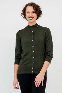 Woman posing in a dark green crew neck merino wool cardigan with front buttons
