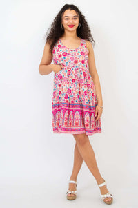 Woman posing in a floral sleeveless dress with hands at her waist