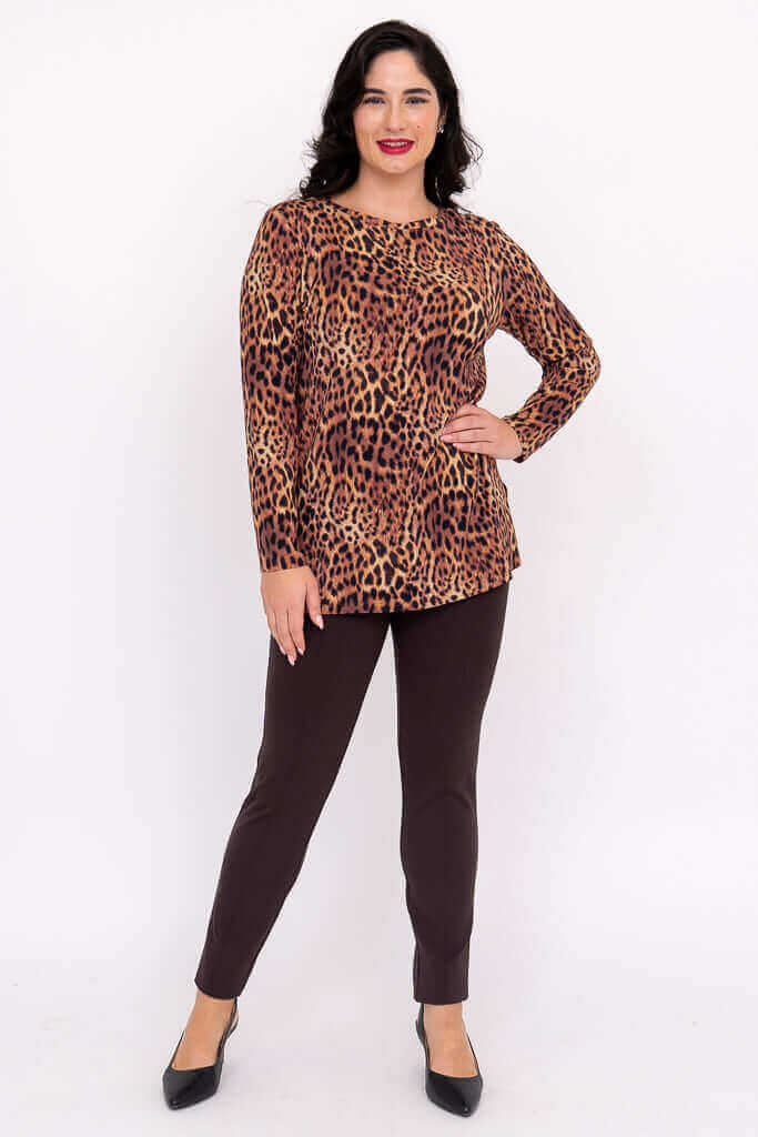 Woman posing in a leopard print long sleeve top with one hand on hip