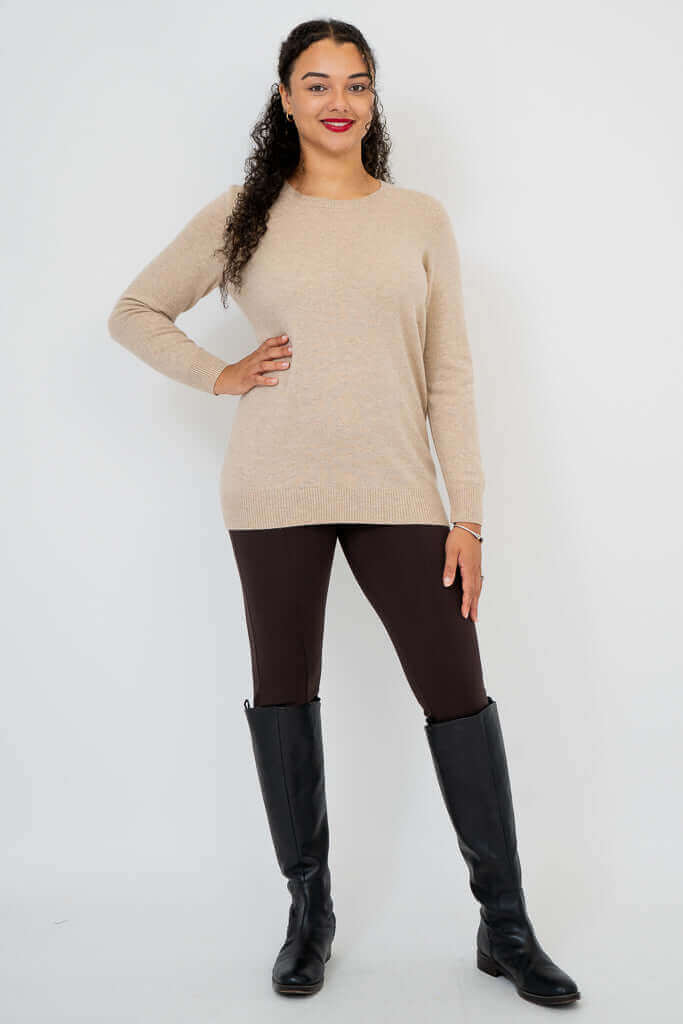 Woman posing in beige wool cashmere sweater with one hand on hip