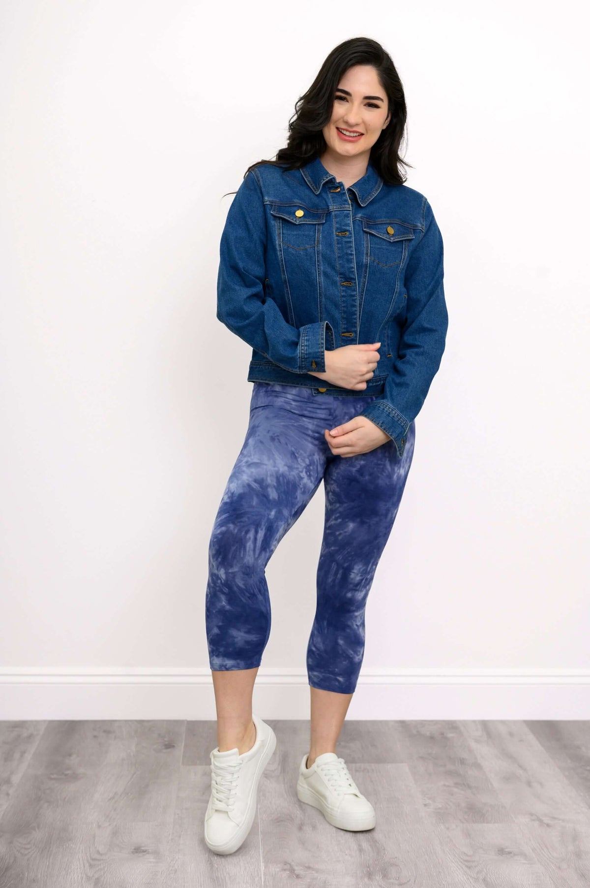 Woman posing in blue tie-dye capri leggings with denim jacket