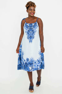 Woman posing in a flowy light blue dress with vibrant blue botanical patterns, front angle