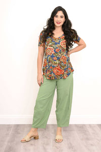Woman posing with hand on hip, showcasing flowy floral v-neck bamboo top