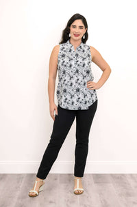 Woman posing with hand on hip, wearing floral zip tank and black pants