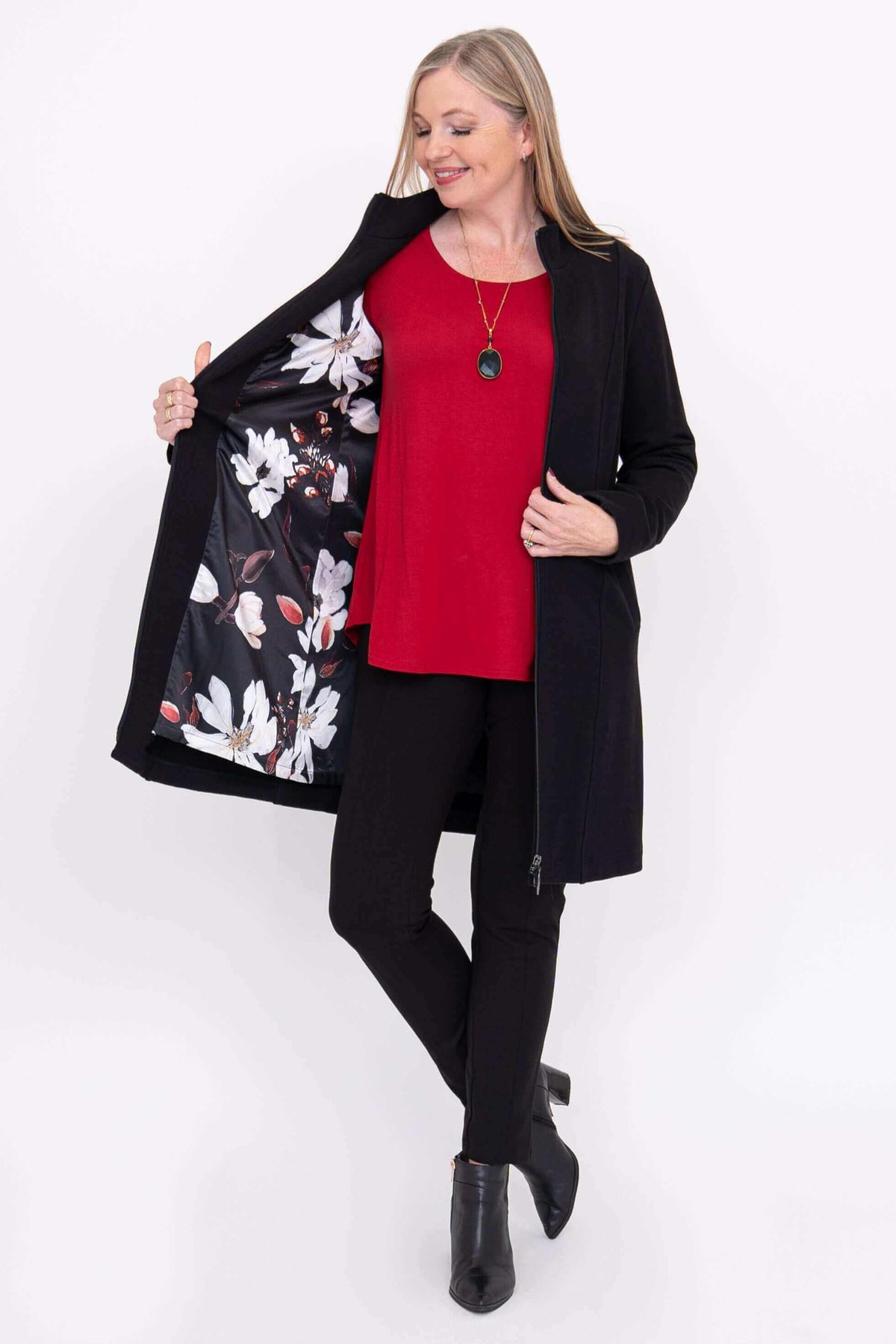 Woman showing floral lining inside black Tracy Coat
