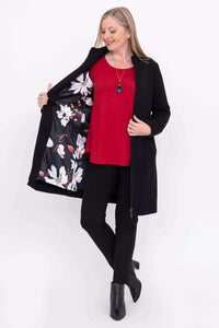 Woman showing floral lining inside black Tracy Coat