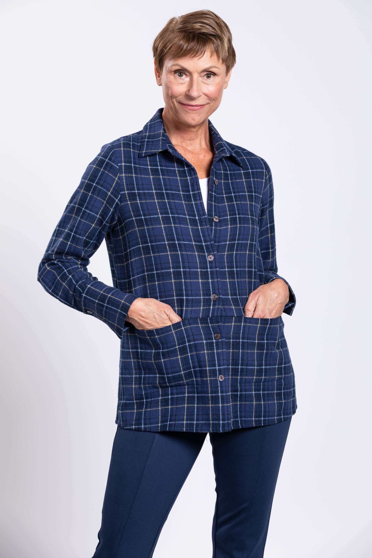 Woman with hands in hidden front pockets of blue plaid cotton jacket