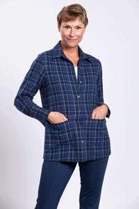 Woman with hands in hidden front pockets of blue plaid cotton jacket