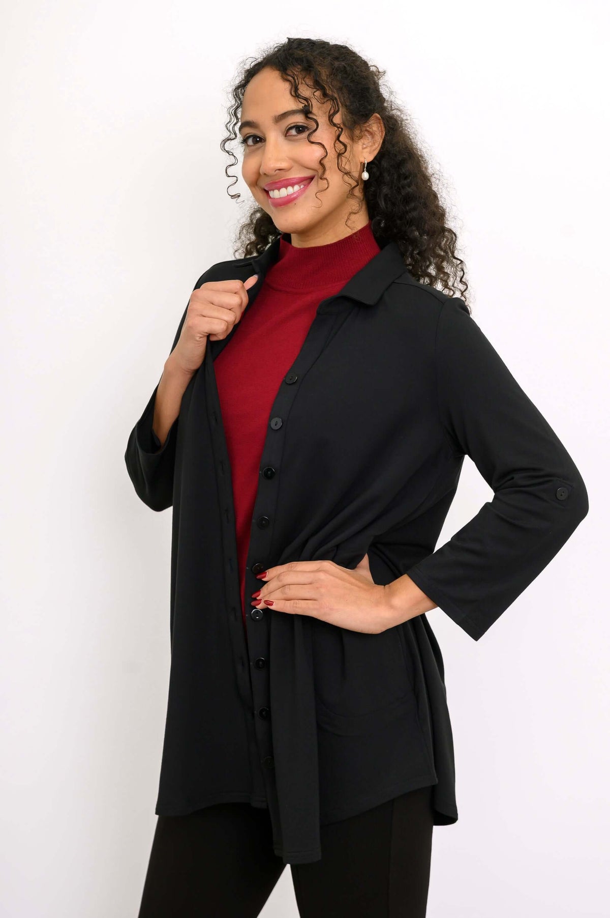 Woman showing open black blouse-jacket over red top, smiling