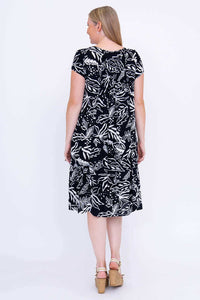 Woman showing the back view of a black and white leaf print dress