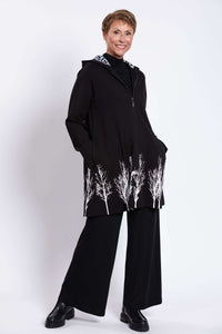 Woman smiling in Edith Coat with zip front and white tree border design