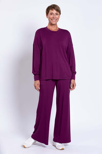 Woman standing and smiling in matching plum bamboo top and pants set