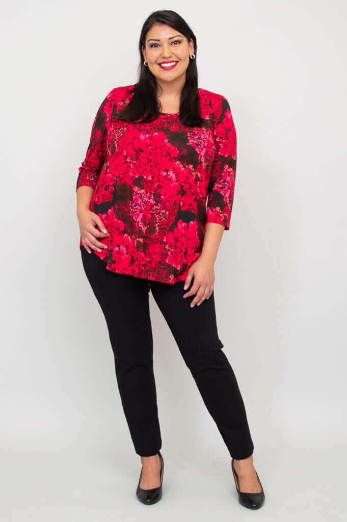 Woman smiling in fuchsia swirl bamboo top with hand on hip
