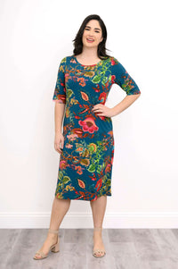 Smiling woman wearing a knee-length teal bamboo dress with bright floral print