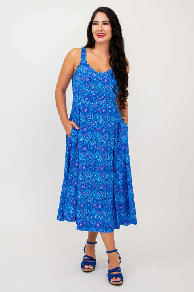 Woman looking to the side wearing blue empire waist midi dress with floral pattern