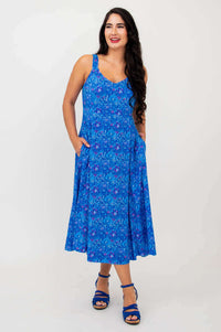 Woman looking to the side wearing blue empire waist midi dress with floral pattern