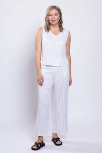 Woman in white pinstripe wide-leg pants and sleeveless top, standing front-facing