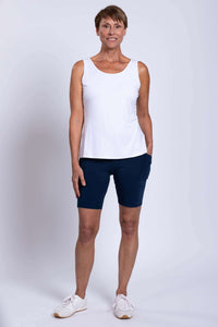Woman standing in navy Robson Shorts and white sleeveless top, front view with hands in pockets